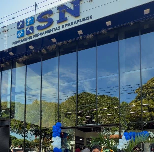 Fachada da SN Ferragens com o letreiro azul e a vitrine de vidro